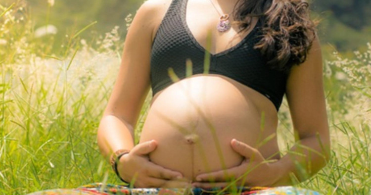 Schwangere Frau hält ihren Bauch